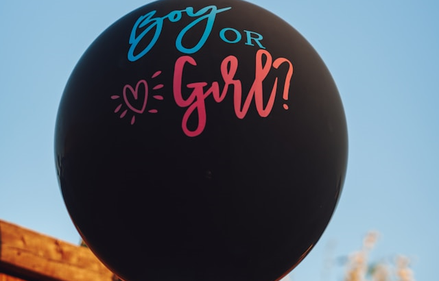 Black gender reveal balloon with 'Boy or Girl?' printed on it in blue and pink lettering